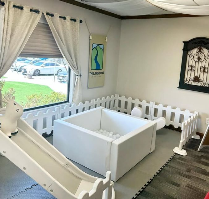 Mini soft play package with ball pit, slide, and safety fence set up indoors